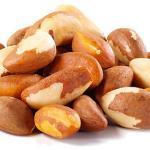 Pile of Brazil nuts with brown and white shells on a white background.